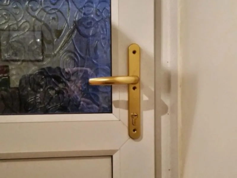 Gold uPVC door handle and lock on a white door