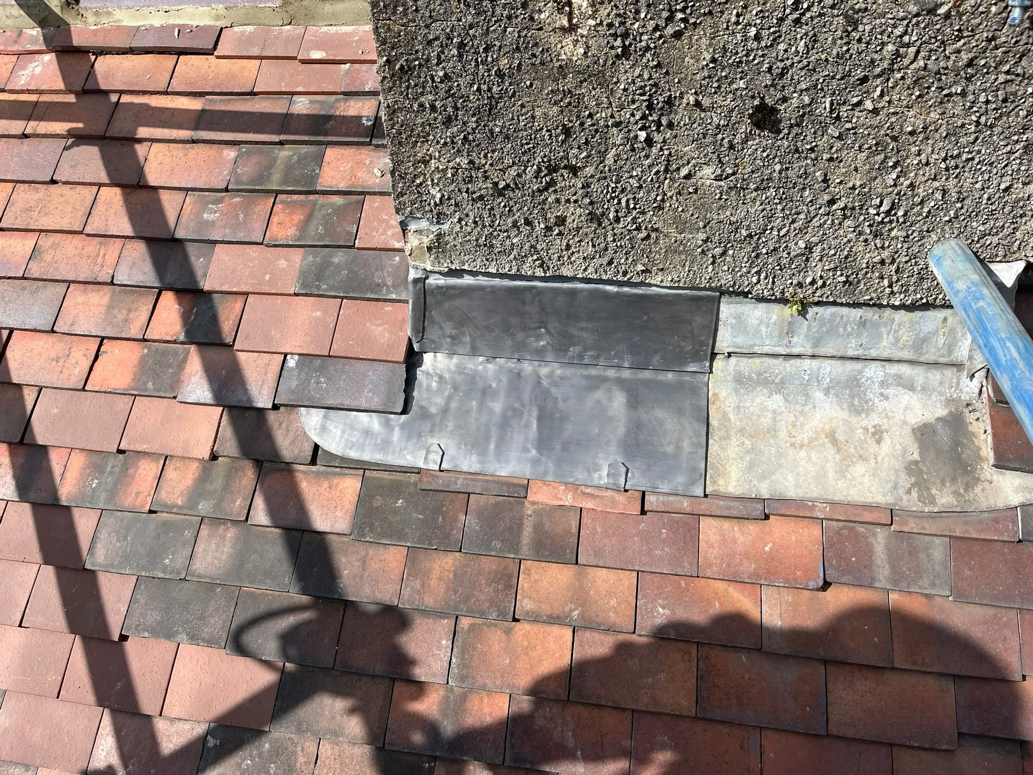 Professional chimney flashing repair on a tiled roof in Gloucestershire.