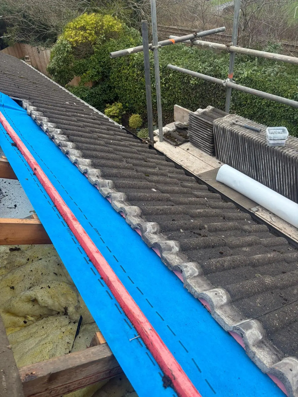Expert tiled roof repair in progress showing new breathable membrane and timber battens being installed