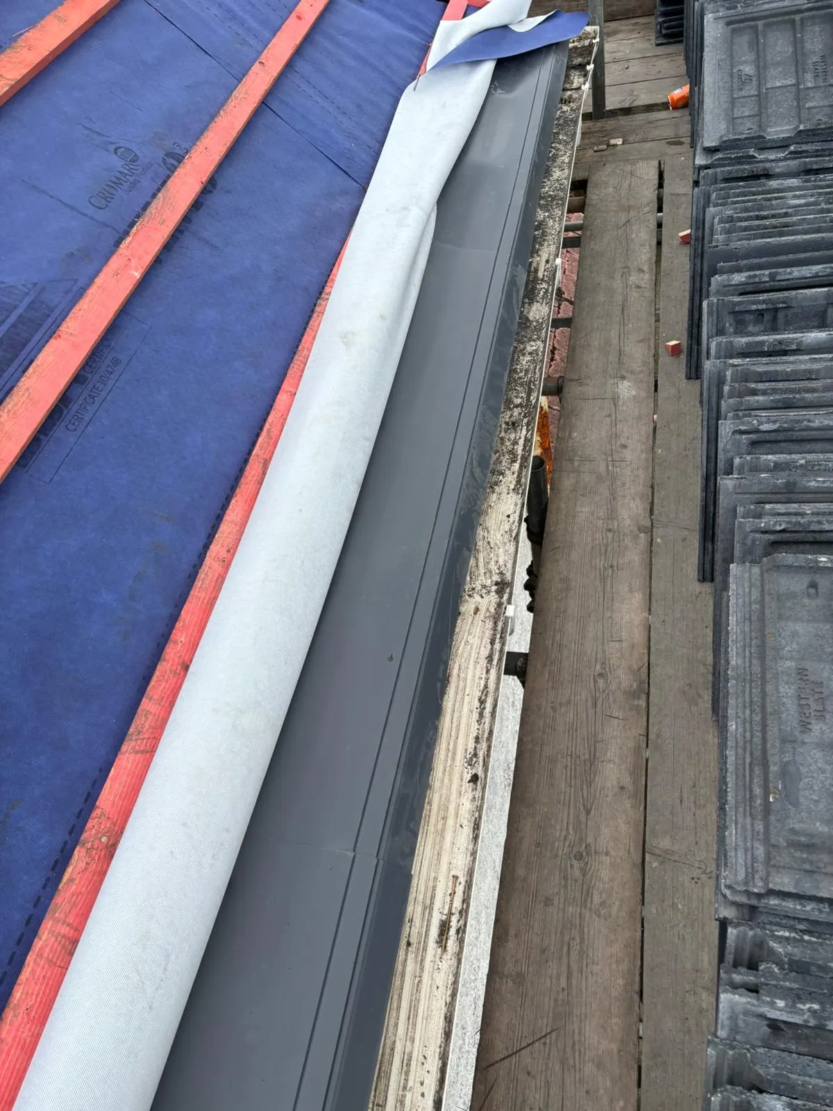 Installation of a new pitched roof showing underlay, battens, and roof tiles
