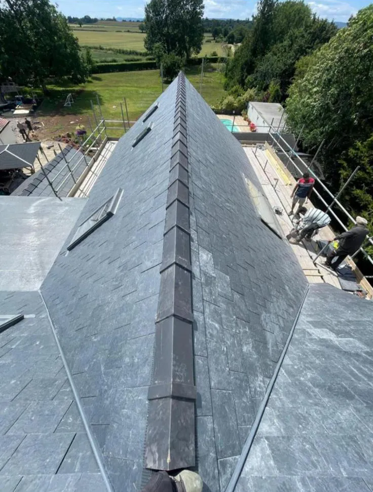 Pitched slate roof installation with dry ridge system and roof windows