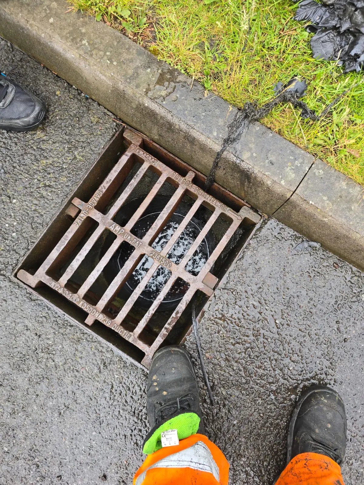 An APJ Drainage engineer preparing to unblock a flooded road gully.