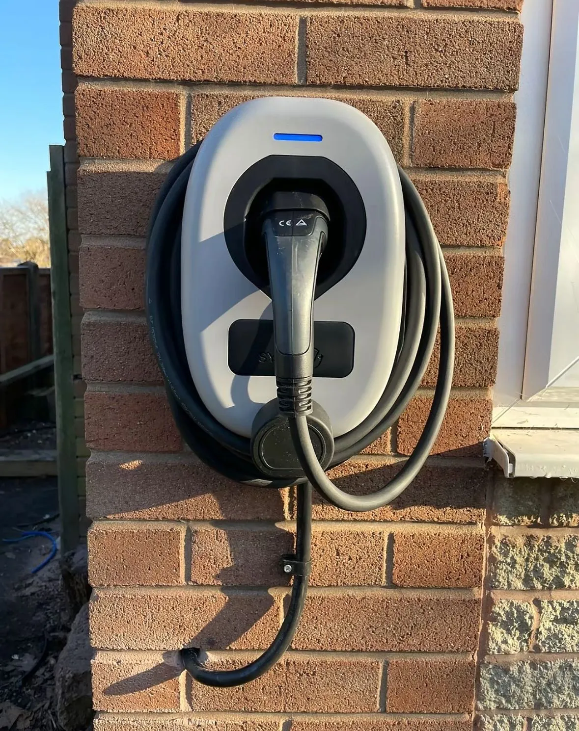 Domestic electric vehicle charging unit installed on an external brick wall by Sussex Brown Sparks