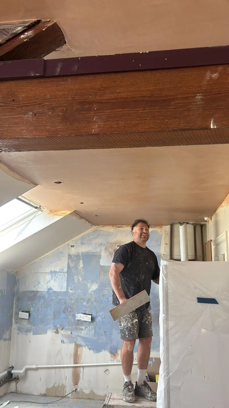 A skilled tradesman from Fortura Construction LTD plastering a ceiling during a high-end home renovation in Tetbury.