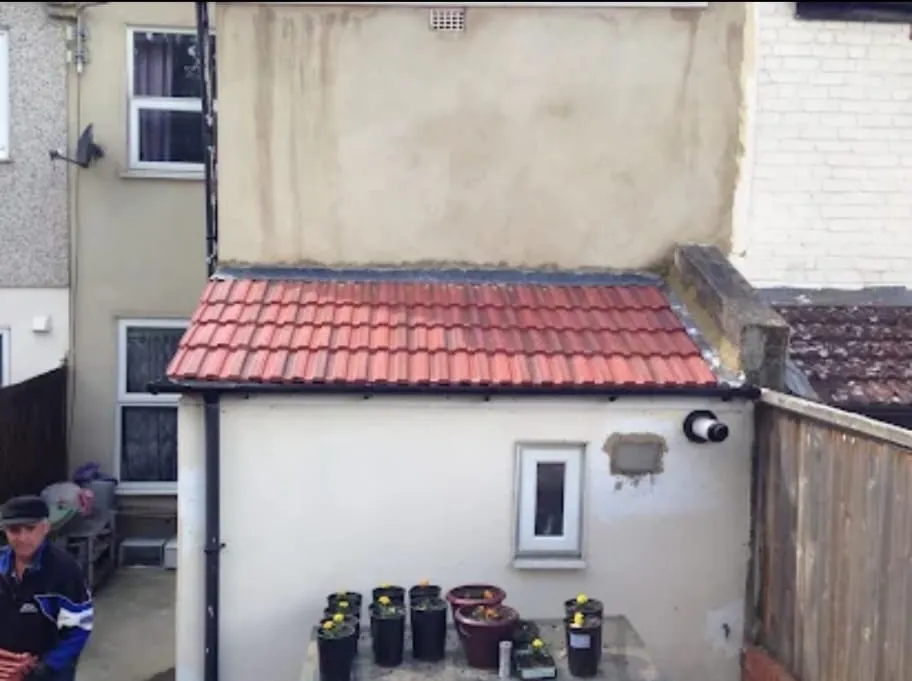 Newly tiled pitched lean-to extension roof with lead flashing and guttering