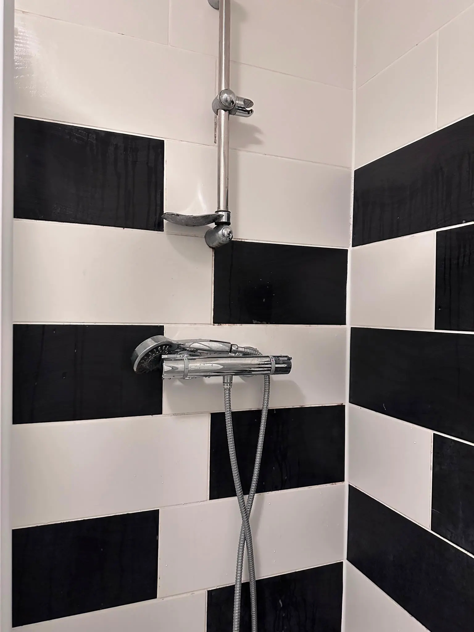 Professional thermostatic shower installation on black and white bathroom tiles by a local Snodland plumber.