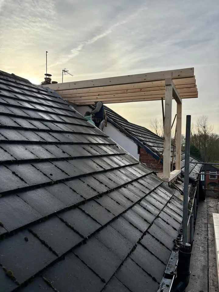 Roofing contractors at Renovation Roofing Ltd working on a timber roof frame for a new installation in West Yorkshire.
