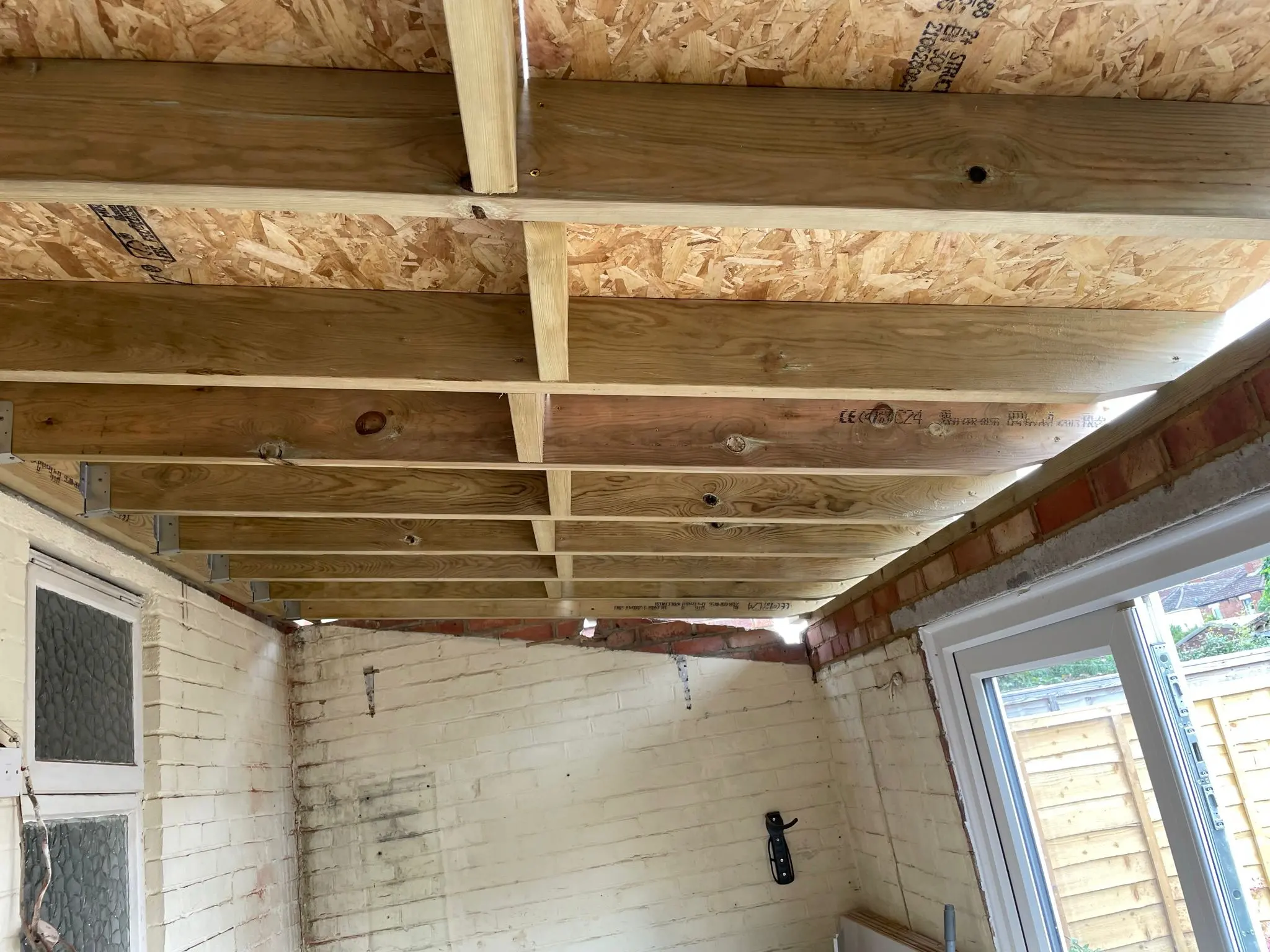 Exposed timber ceiling joists and OSB boarding on a flat roof extension