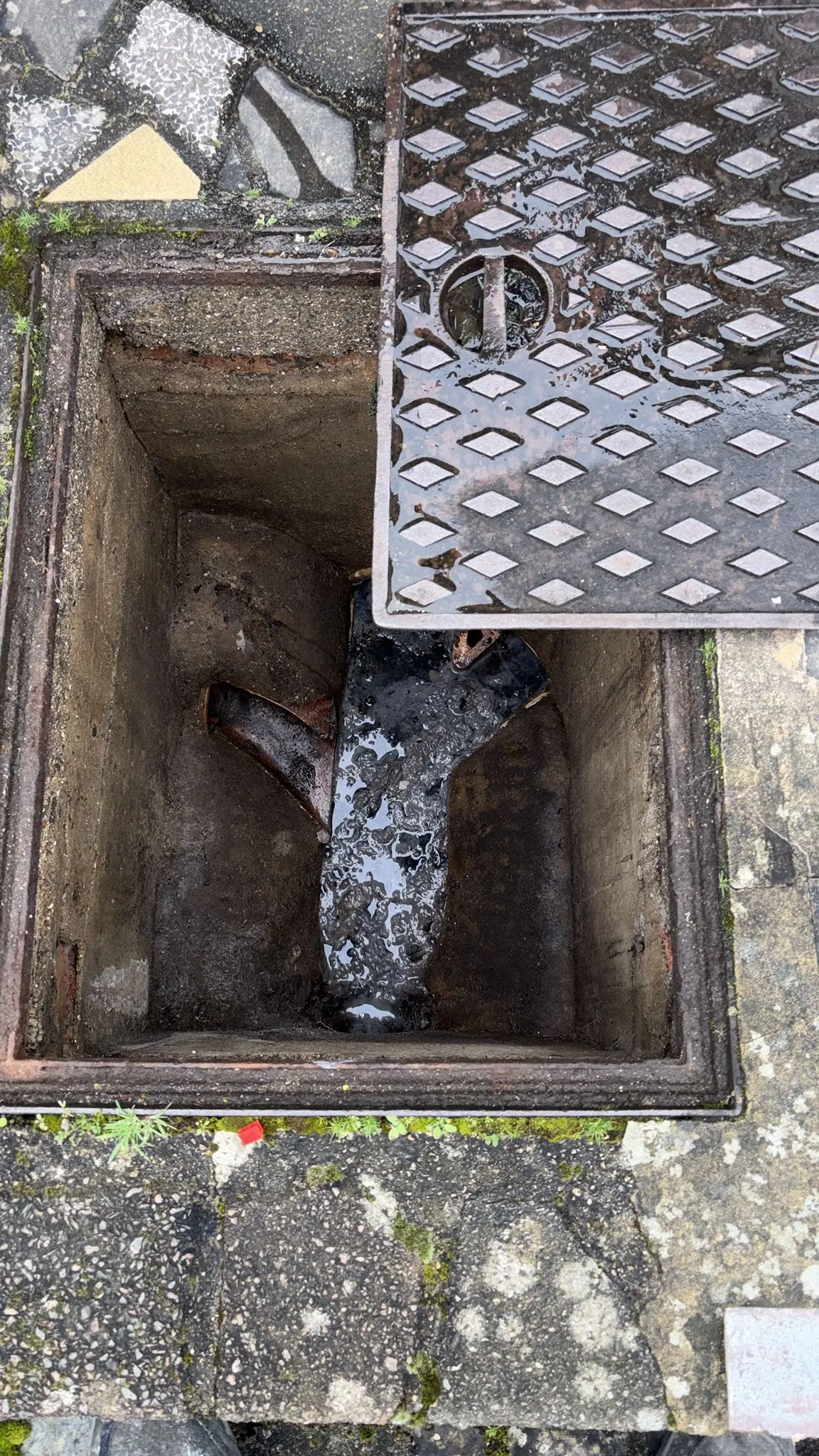 Blocked outdoor drain manhole showing wastewater