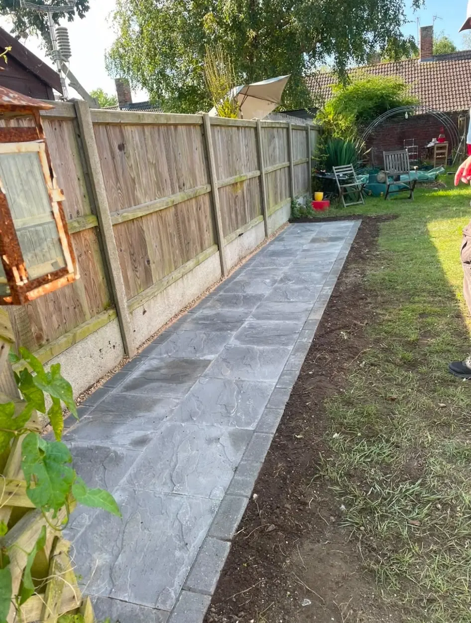 A picture of a newly laid grey stone garden path with decorative block edging