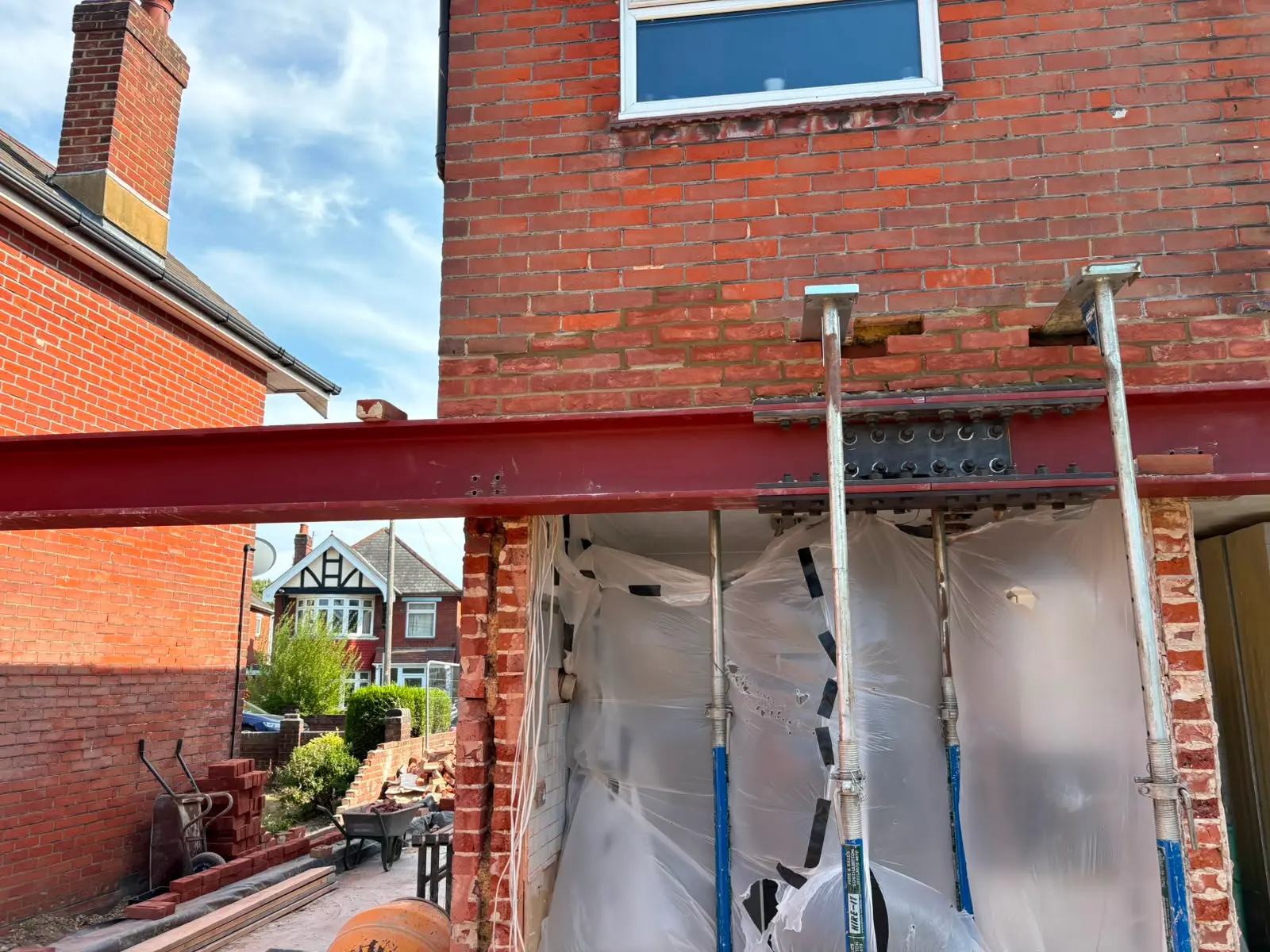 RSJ steel beam installation supported by Acrow props during residential structural alterations by Aline Construction