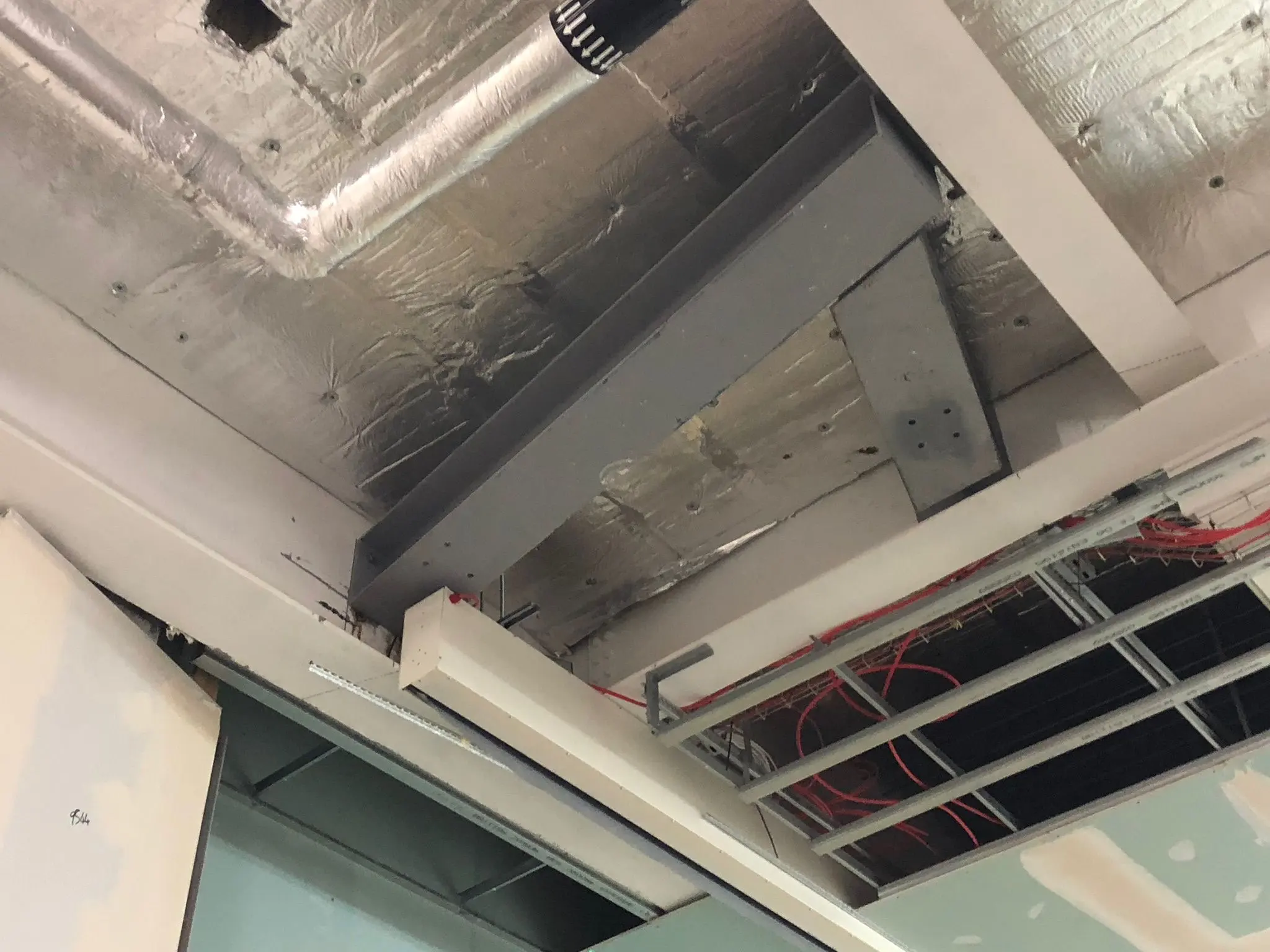 Internal structural steel beam and ceiling insulation installed during a commercial building construction project