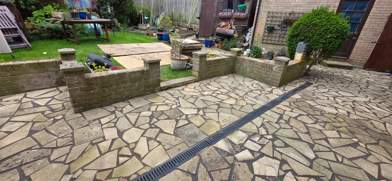 Professional natural stone patio installation with linear drainage by FLEX PROPERTY SERVICES in Felixstowe.