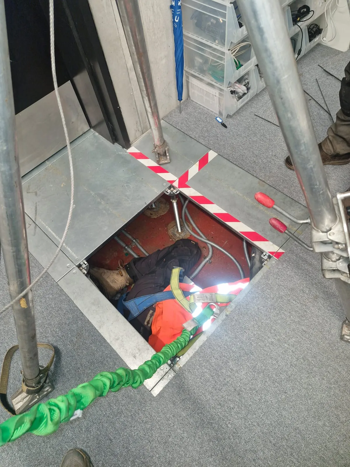 Roberts Drainage Ltd engineer using safety equipment for confined space entry in a commercial building.