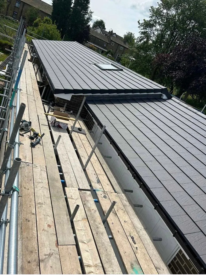 Newly installed tiled roof with dark grey slates and scaffolding in Holmfirth