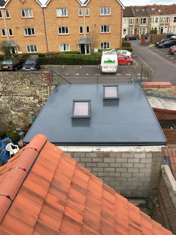 Newly installed grey flat roof with two skylights completed by Amac Roofing