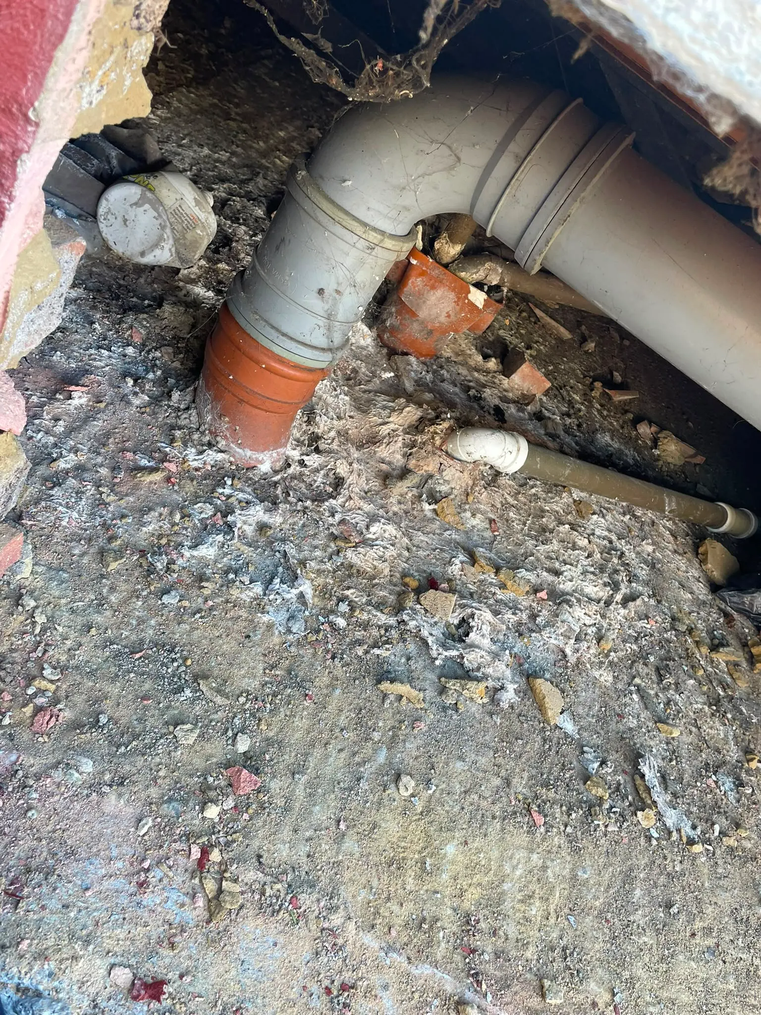 Image showing a leaking waste pipe and raw sewage buildup in a sub-floor crawl space.