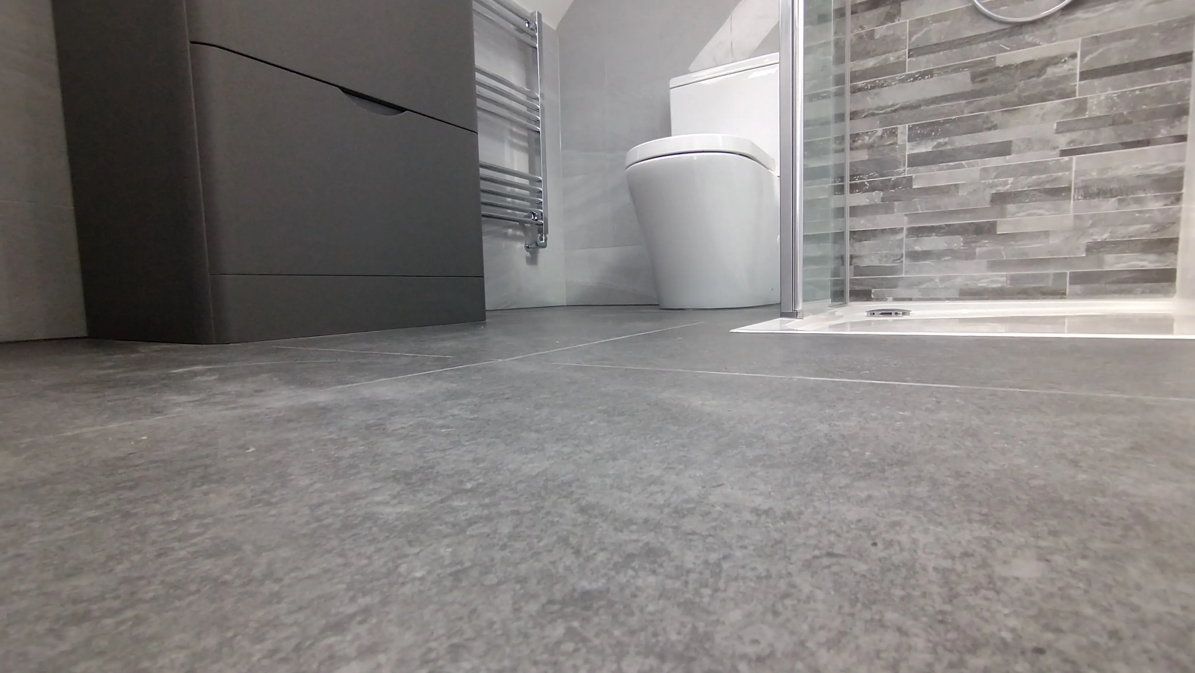Bespoke luxury bathroom installation in Plymouth featuring modern grey tiling and a walk-in shower by Sands & Vossen.