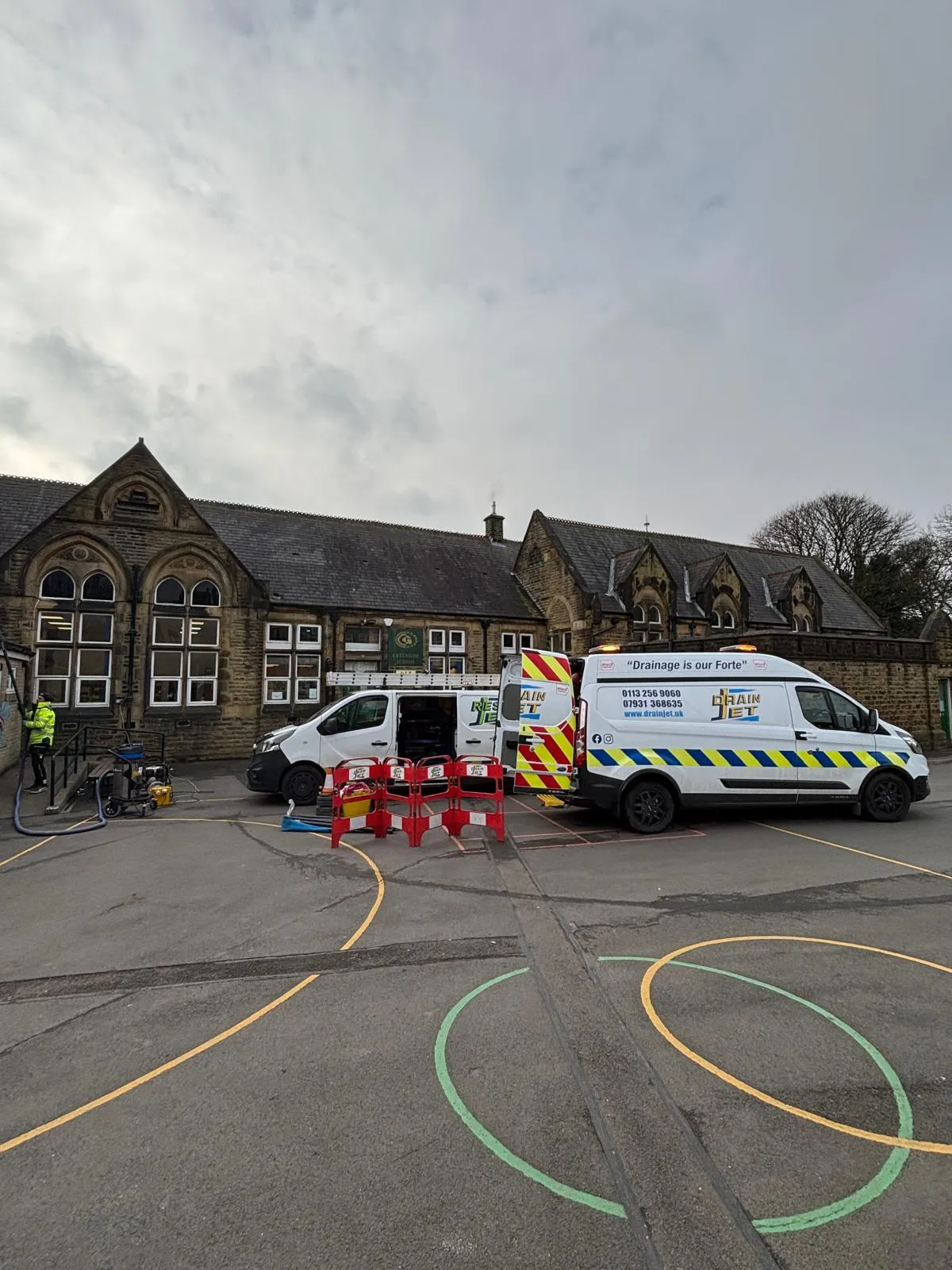 Drain Jet commercial drainage service vans on-site at a school in Leeds for drain clearance and maintenance.