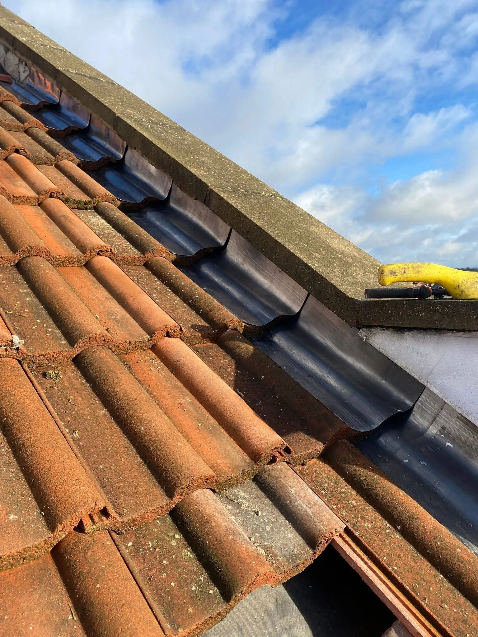 Professional leadwork and flashing installation on a tiled roof by NTL Roofing.