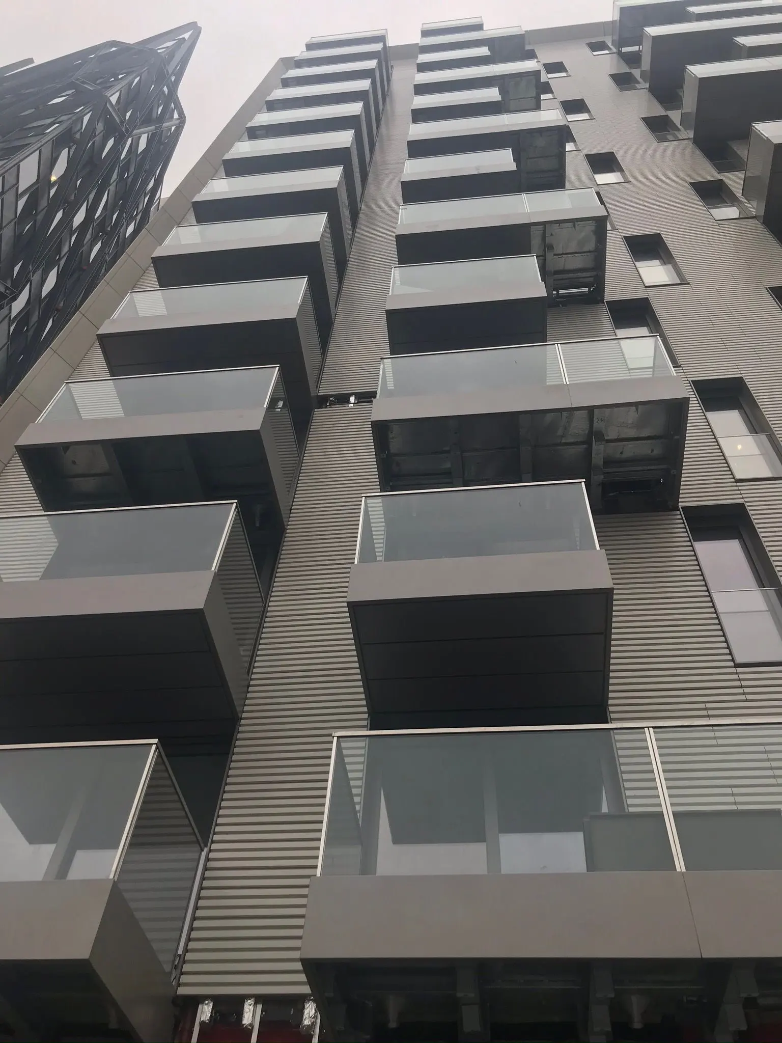 Modern commercial building exterior showcasing weather-resistant corrugated cladding and structural steel balconies