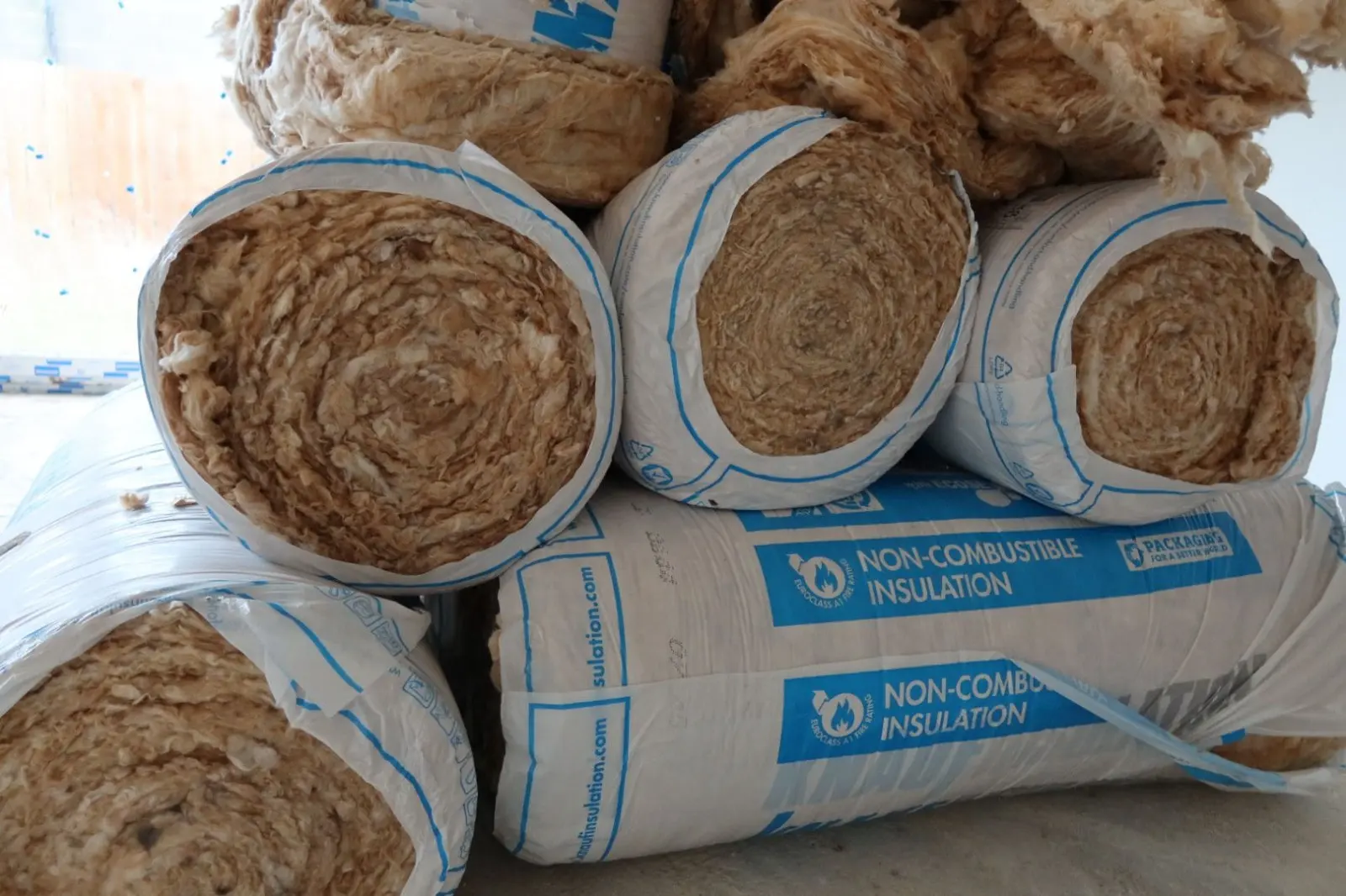 Rolls of non-combustible fibreglass loft insulation ready for installation