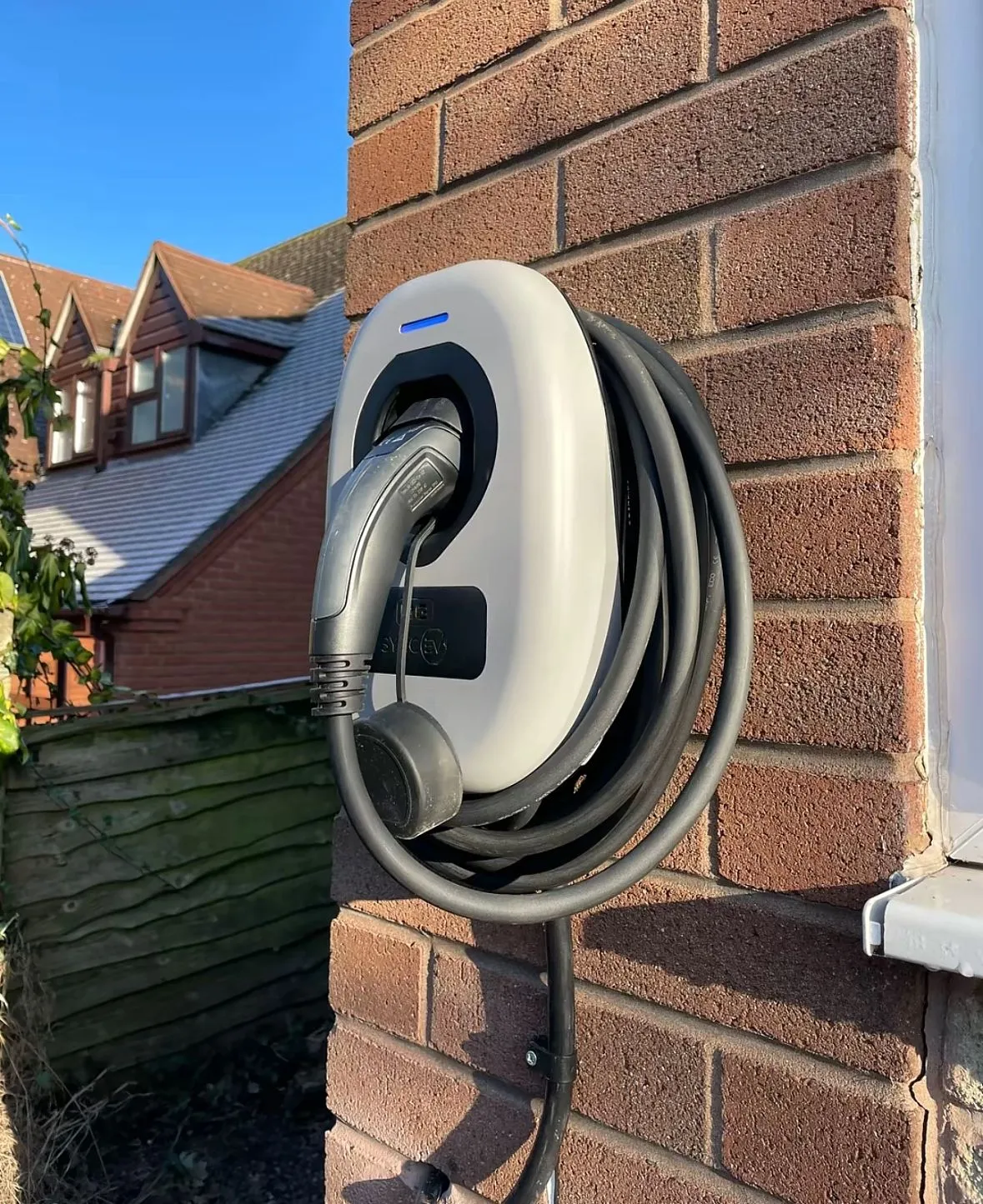 Wall-mounted domestic EV charger installation on an exterior brick wall