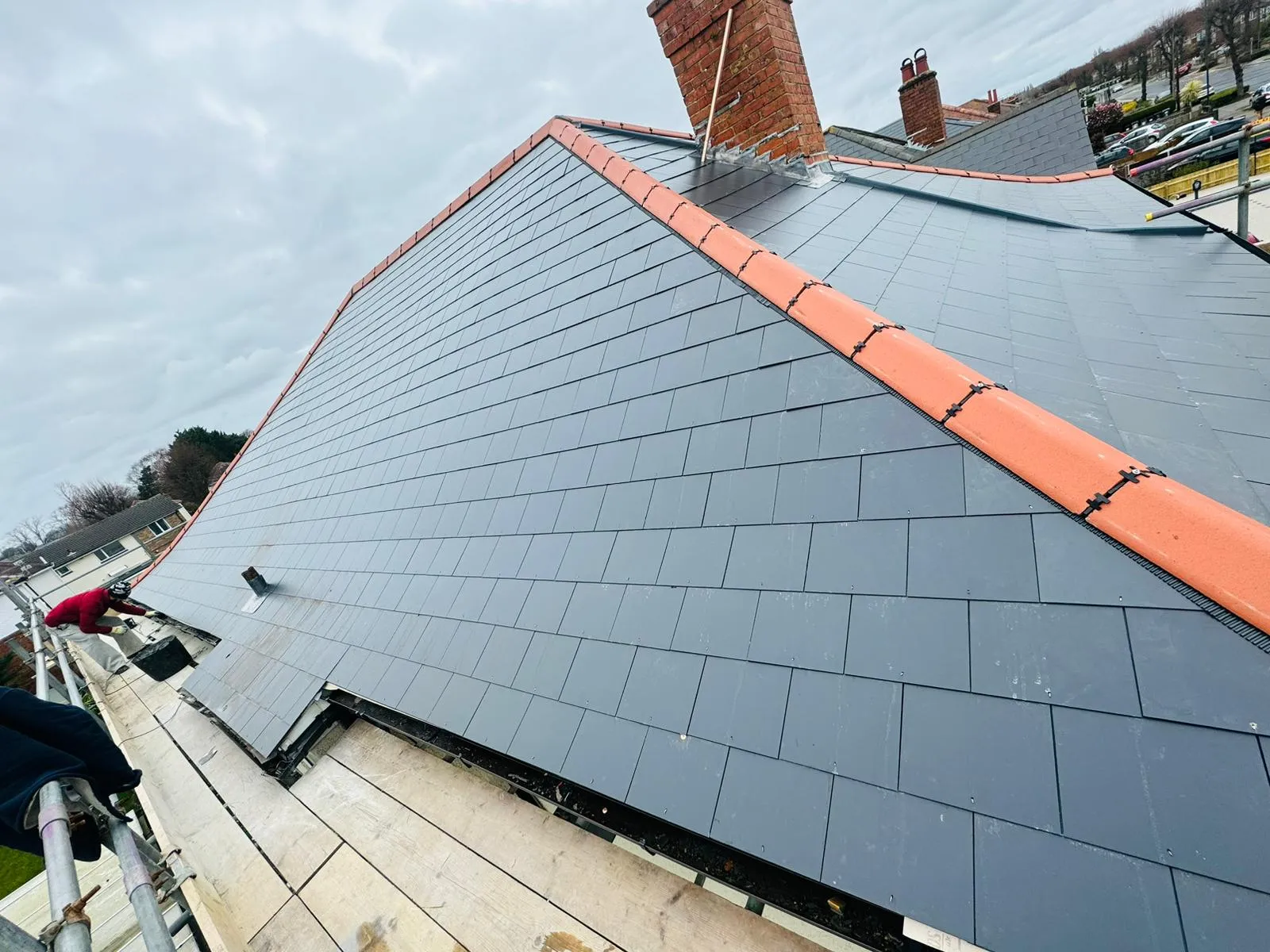 A newly installed grey slate pitched roof with orange ridge tiles on a house in Portsmouth
