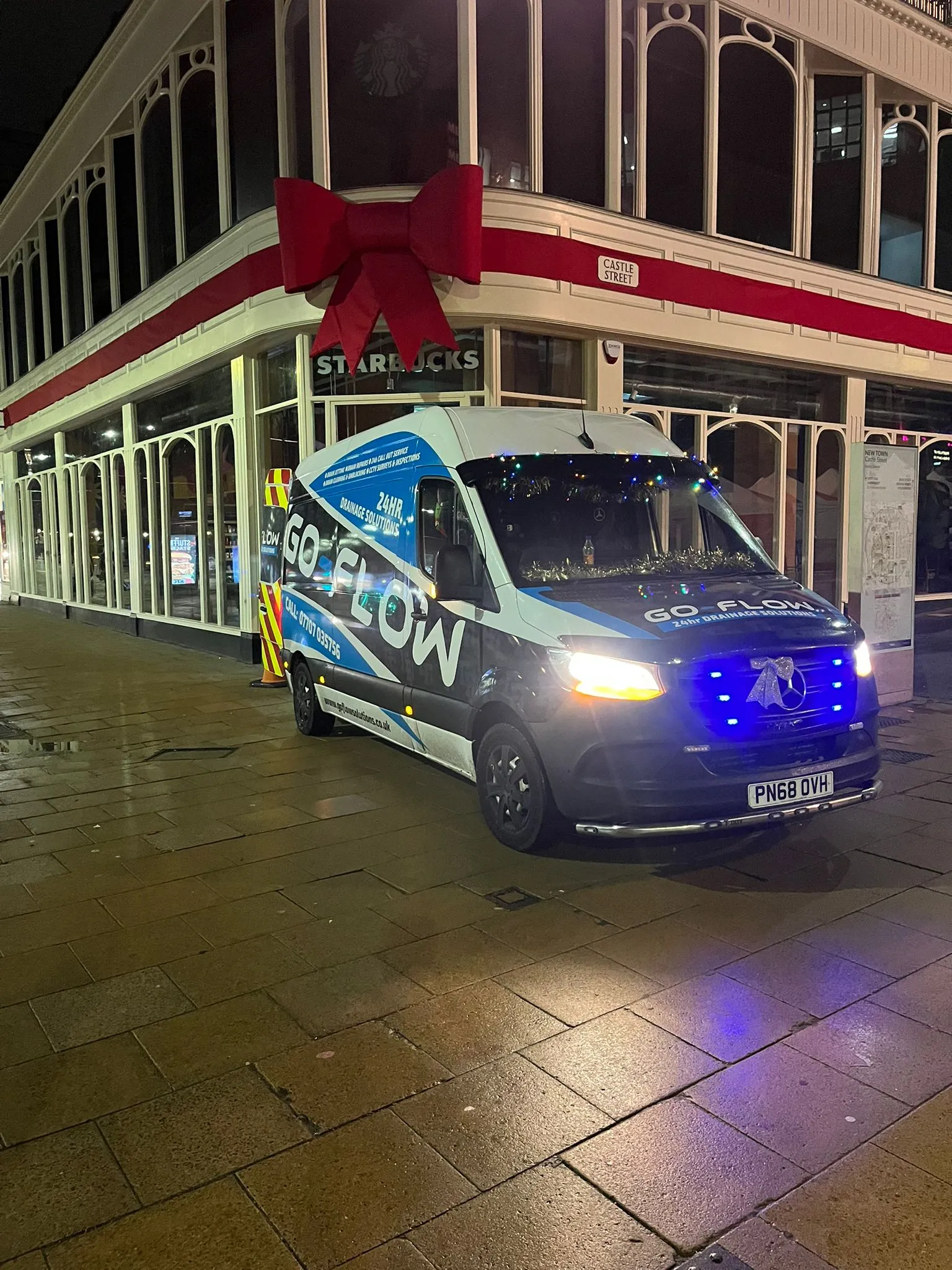 Go Flow Solutions Edinburgh branded drainage services van parked on Castle Street at night, showcasing their 24-hour service.
