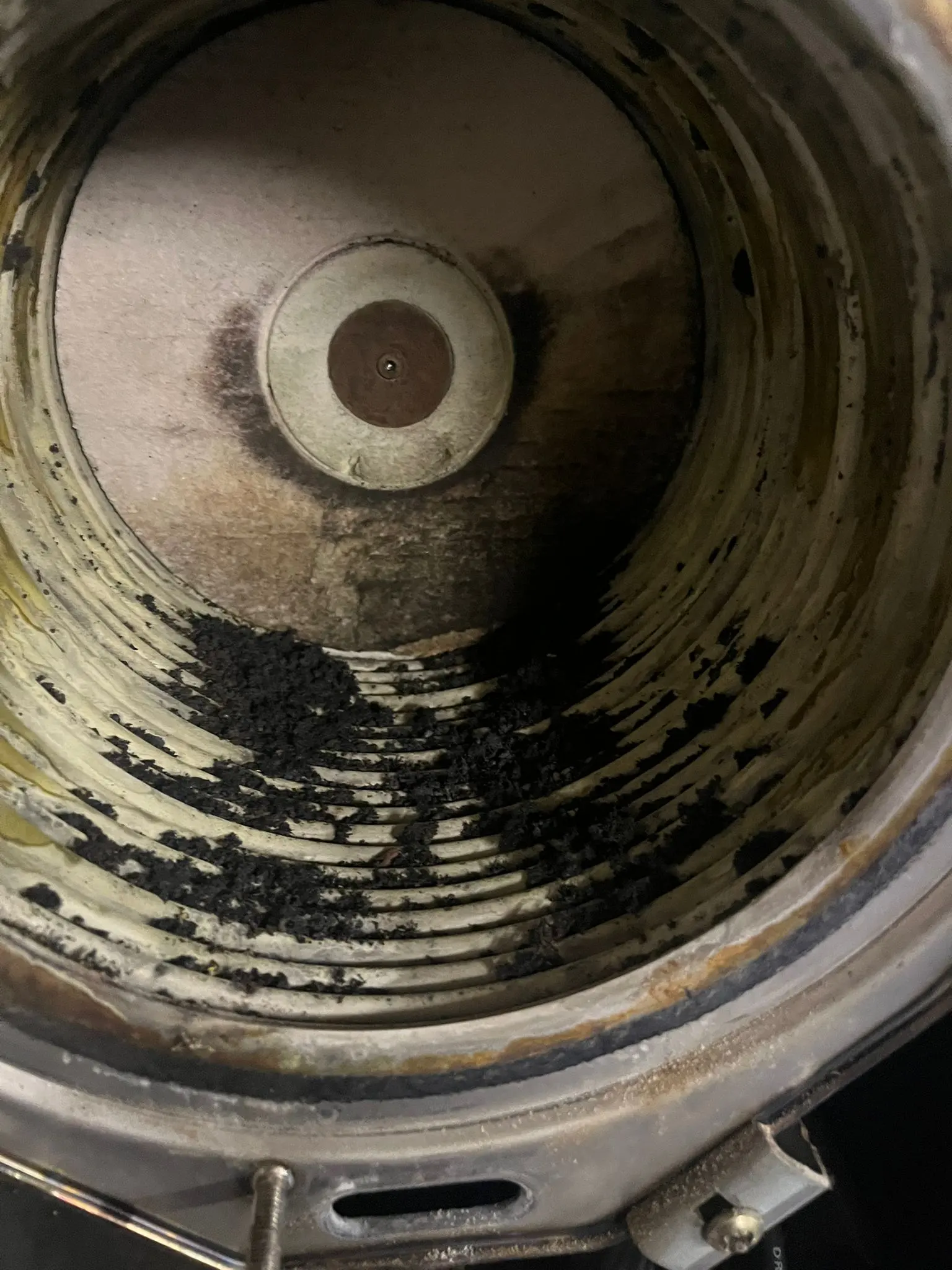 Internal view of a dirty gas boiler heat exchanger showing carbon buildup