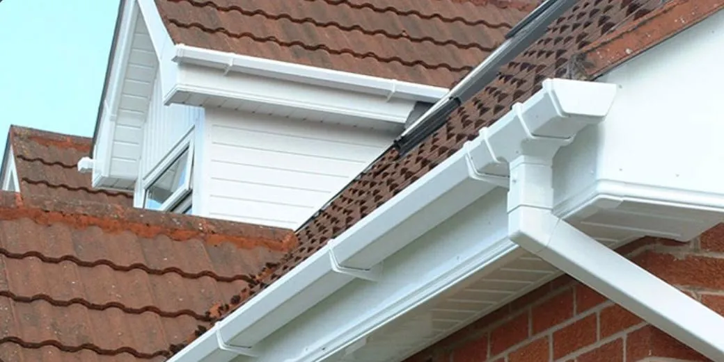 Modern white uPVC guttering, fascias, and soffits installed on a residential roof in Devon.