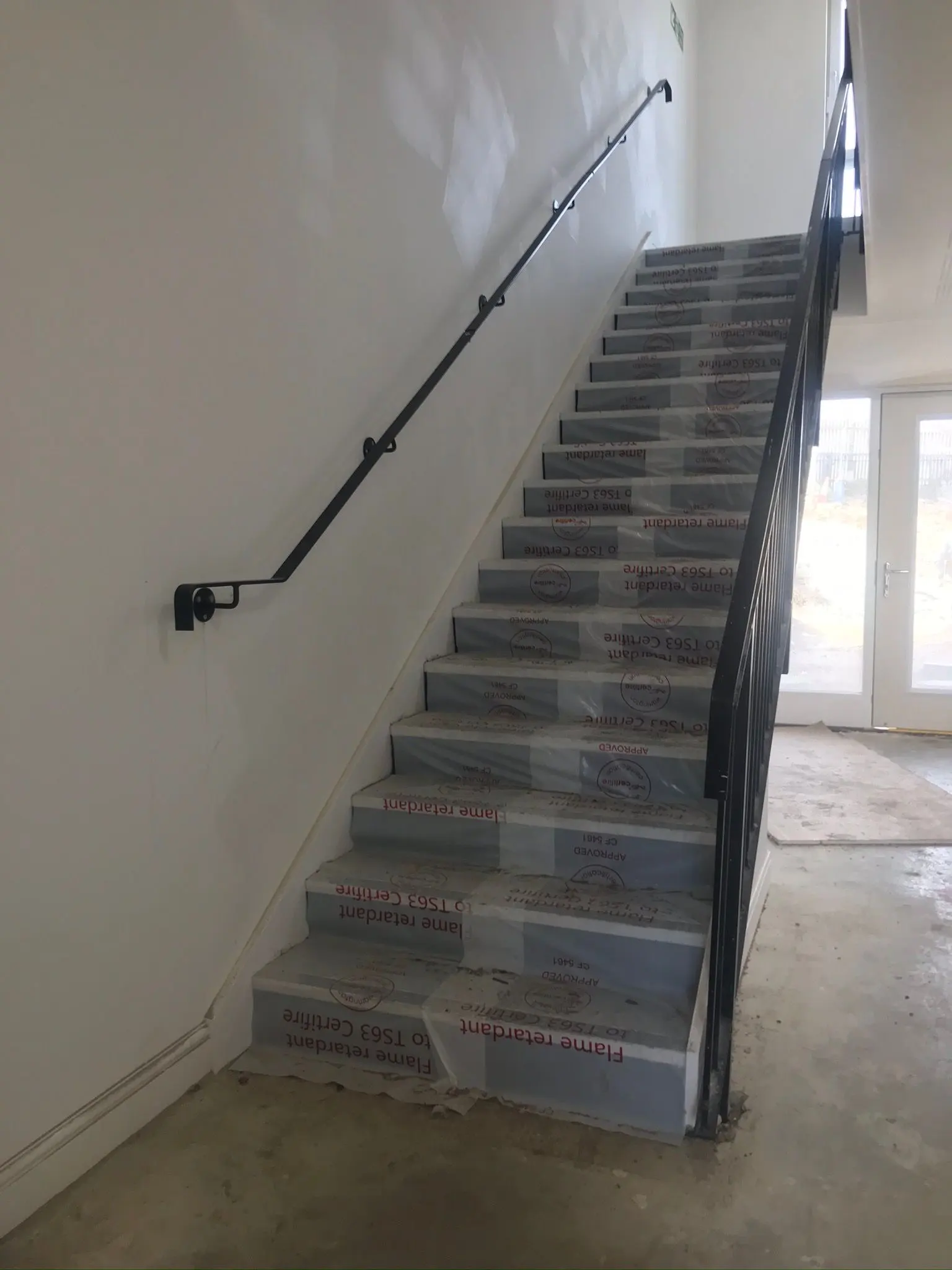 Newly constructed interior staircase with protective covering in an industrial unit built by ER3 Group LTD
