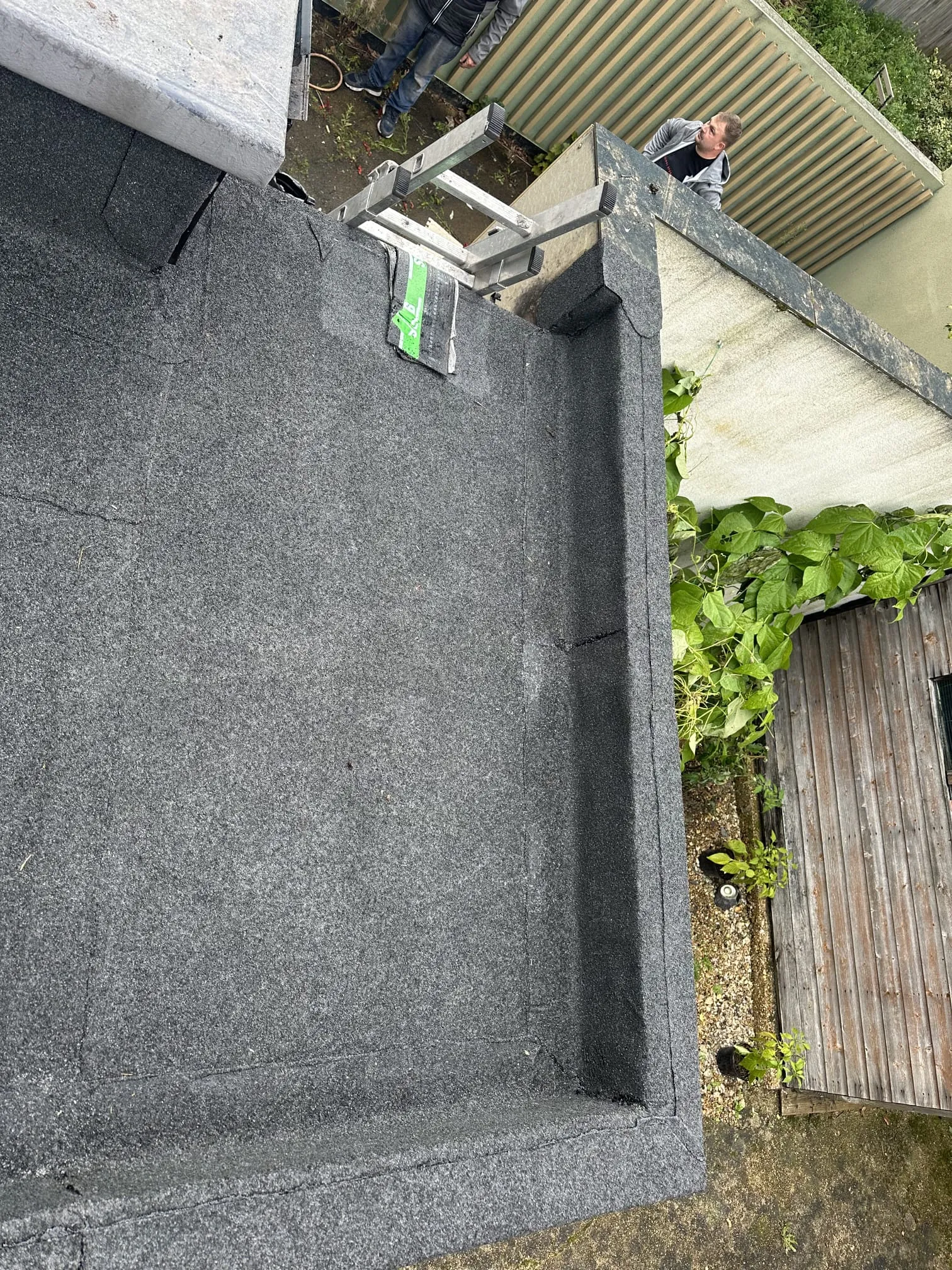 A picture of a flat roof being installed with high-performance mineral felt.