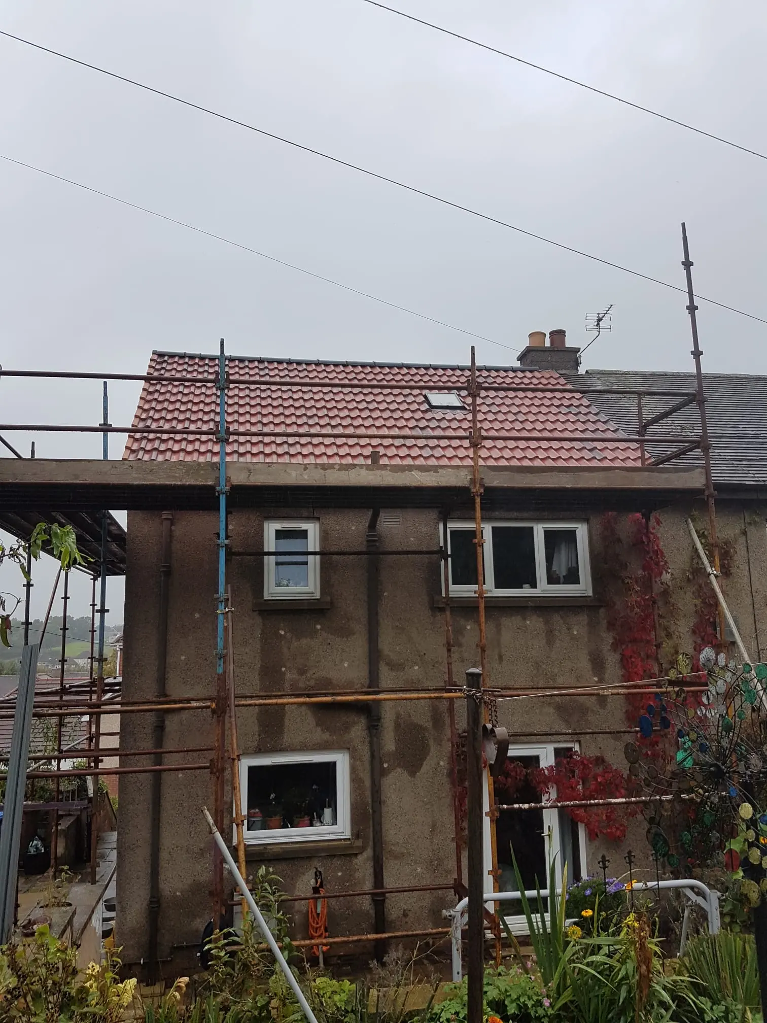 A house in Fife with scaffolding undergoing a new tiled roof installation by RM & SON ROOFING & PROPERTY CARE