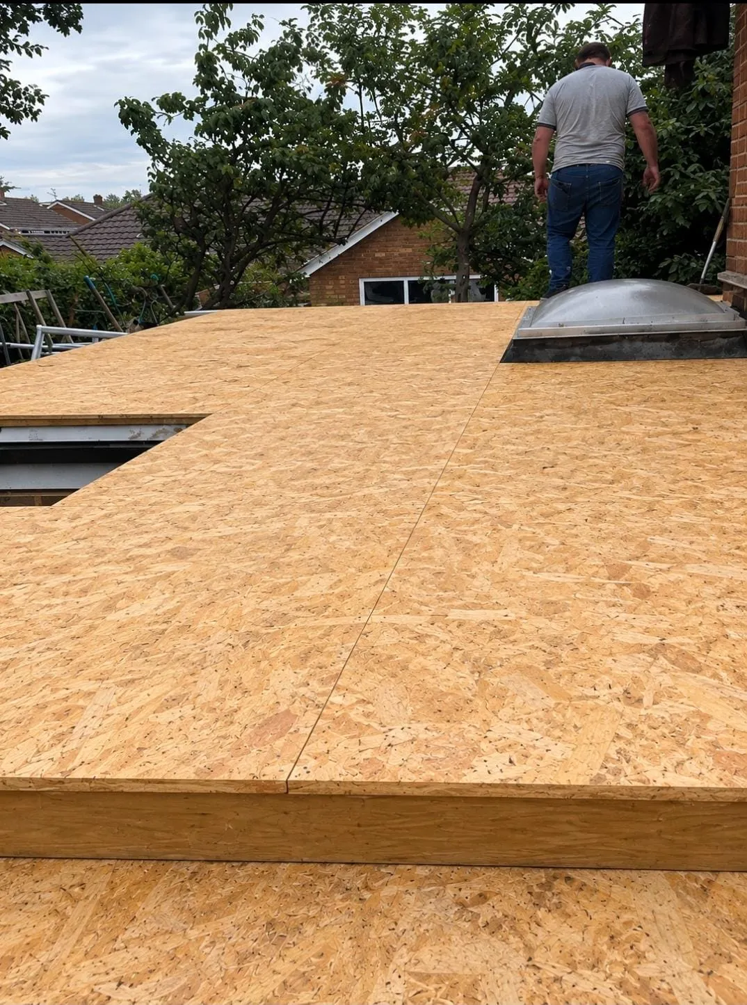 Freshly laid OSB flat roof timber decking boards on a residential extension preparing for waterproofing