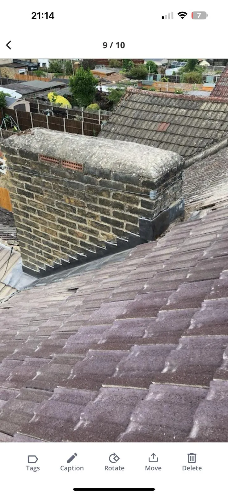 Brick chimney with lead flashing on a tiled roof, showing professional repairs by HomeGuard Roofing Ltd.