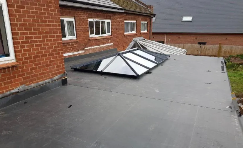 A modern flat roof extension with a prominent glass roof lantern, showcasing expert flat roofing installation and natural light integration.