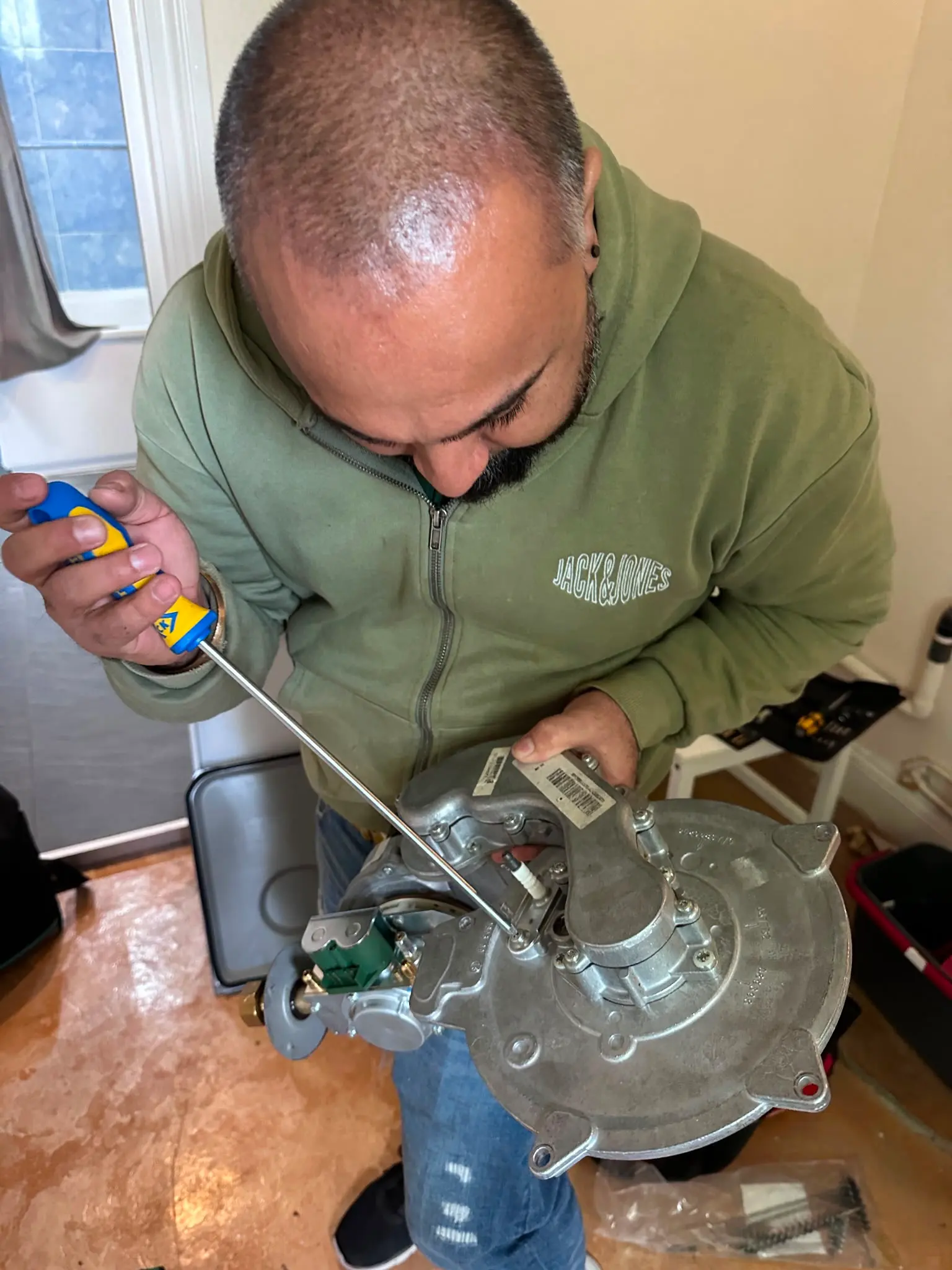 Gas Safe registered engineer from JMA Plumbing & Heating performing an emergency boiler repair on a fan assembly in Kent