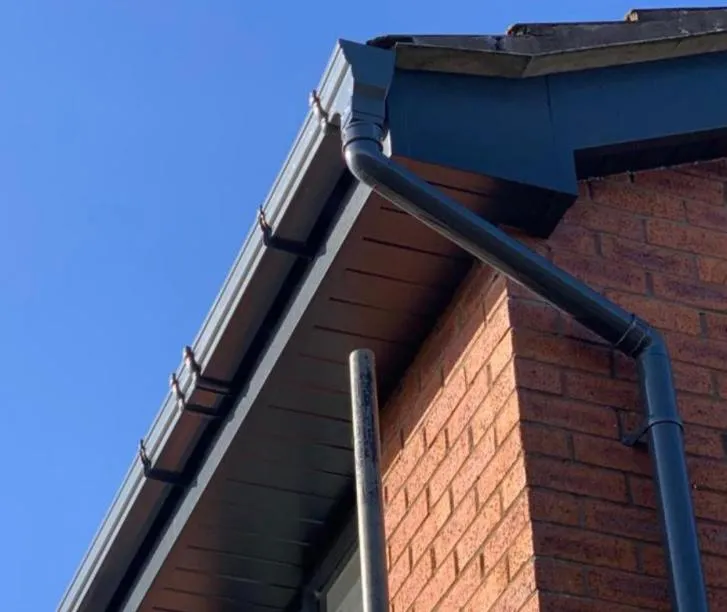 New dark grey UPVC fascias, soffits, and guttering on a house.
