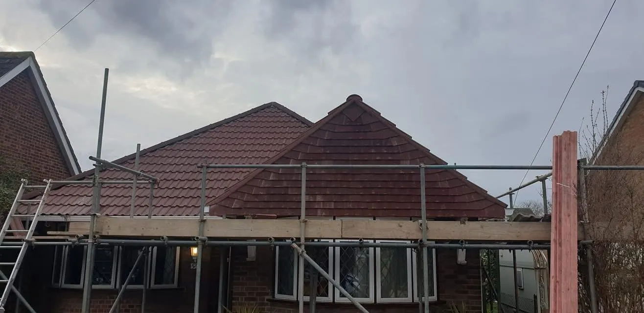 New tiled roof installation on a house with scaffolding.