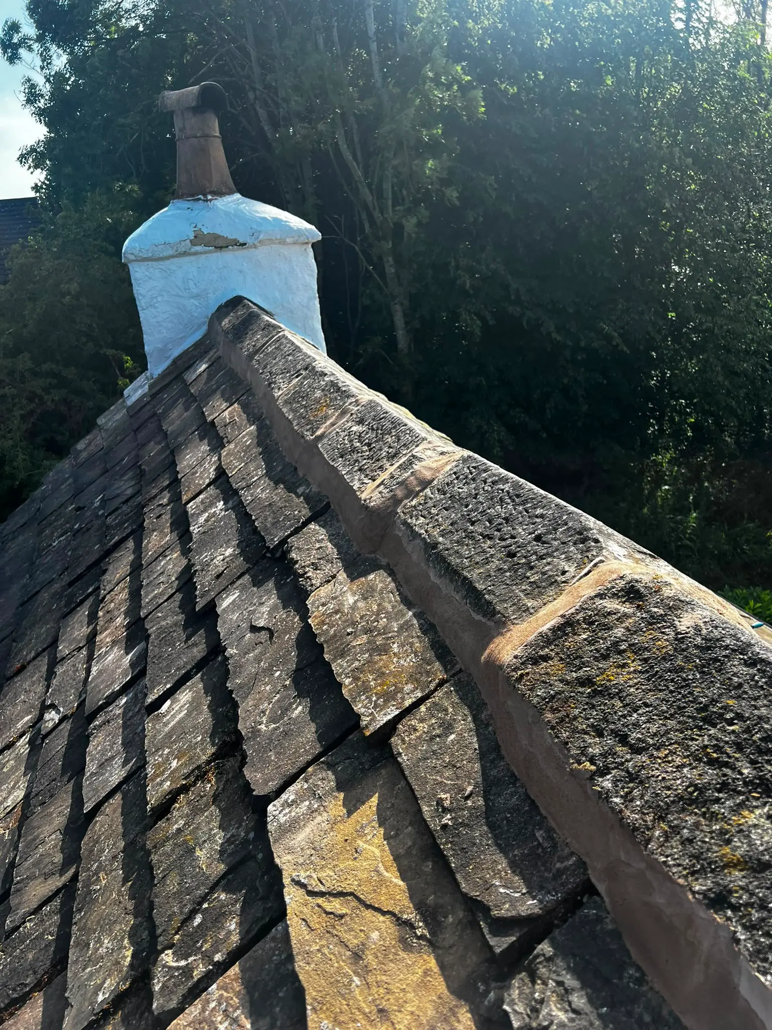Repointed ridge tiles on a slate pitched roof in Burnley.