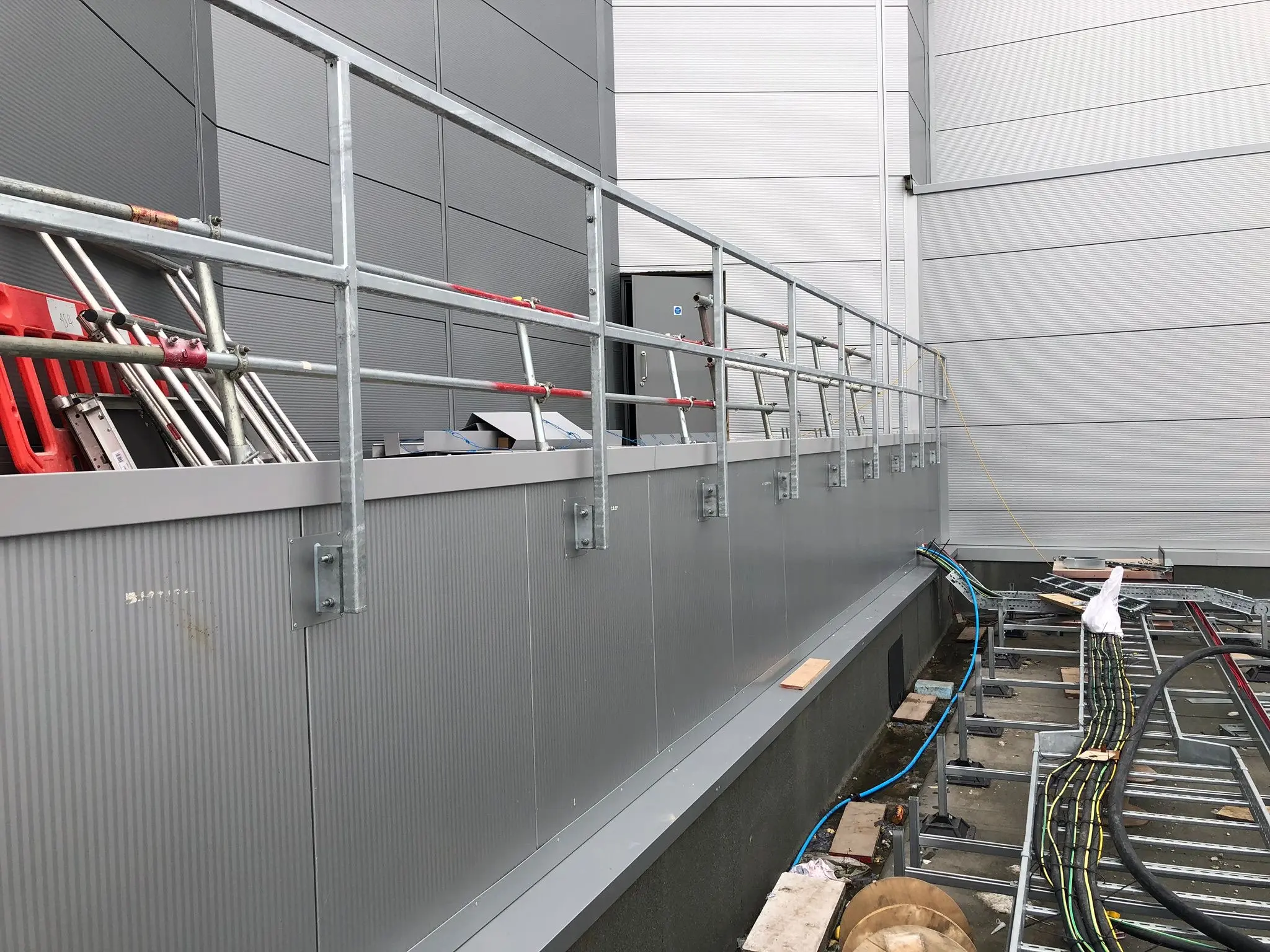 Weather-resistant metal cladding and safety edge protection guardrails installed on an industrial unit build