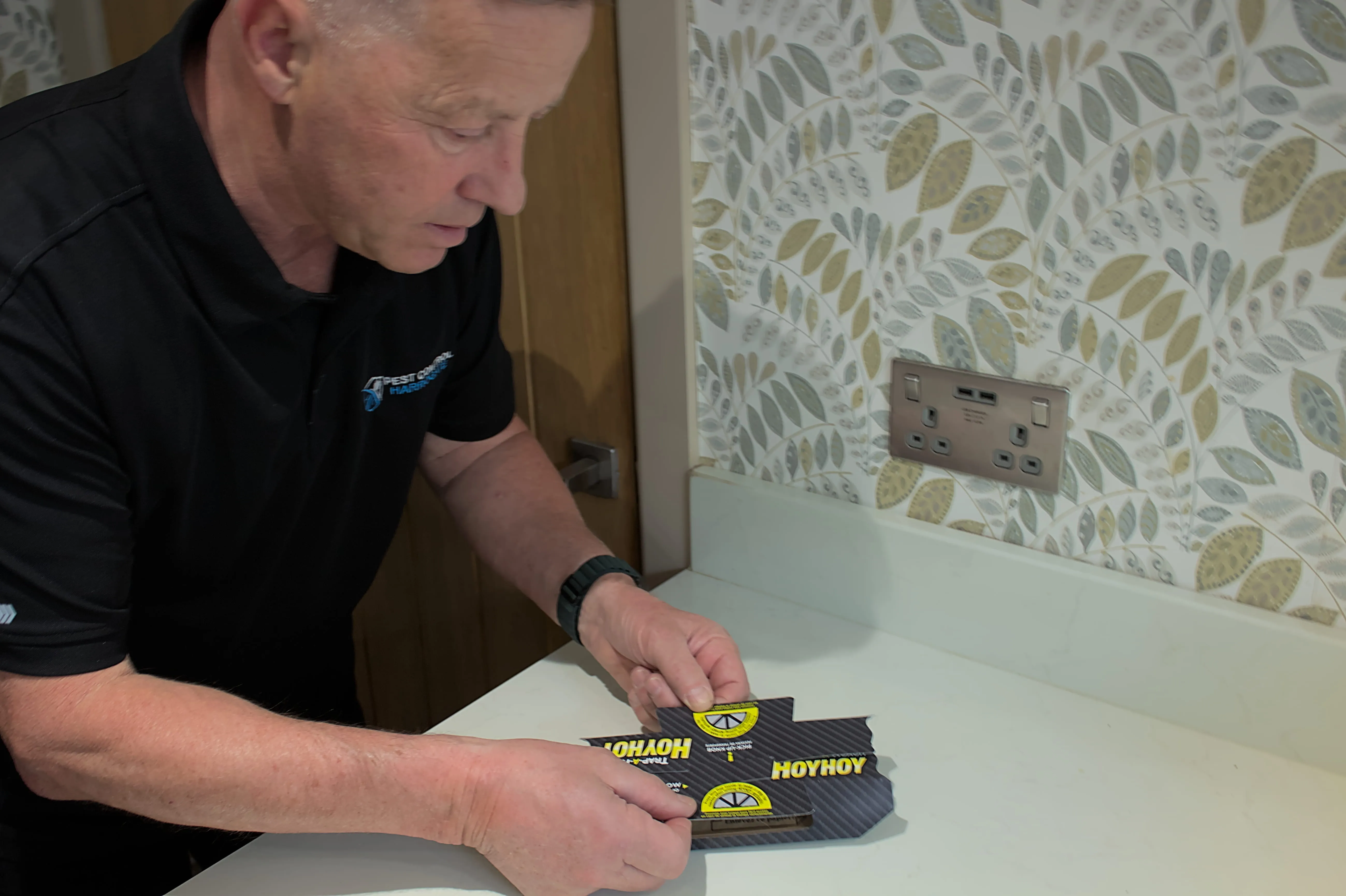 A Pest Control Harrogate technician placing a cockroach trap in a domestic property during a pest inspection.