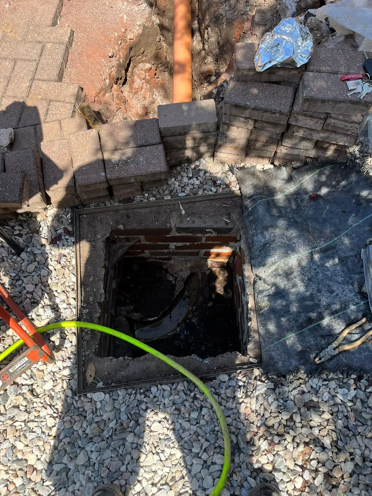Open manhole chamber and newly installed drainage pipe during an excavation and groundworks project by CB Drainage