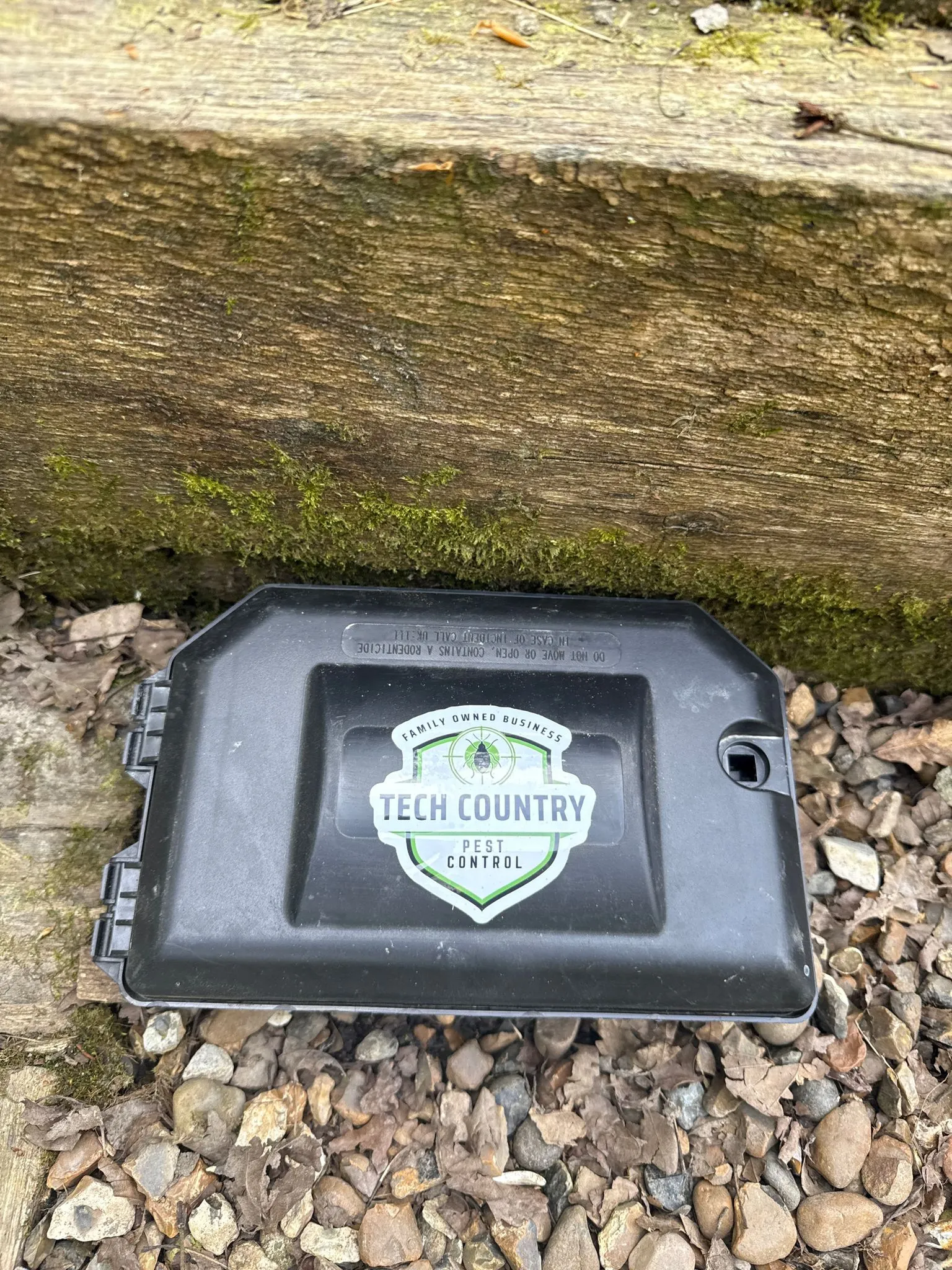 A Tech Country Pest Control rodent bait station on the ground