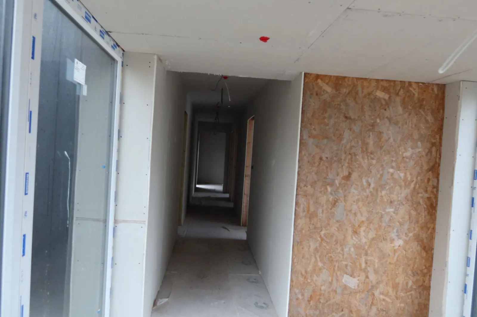 Interior hallway undergoing renovation with plasterboard installed for internal wall insulation