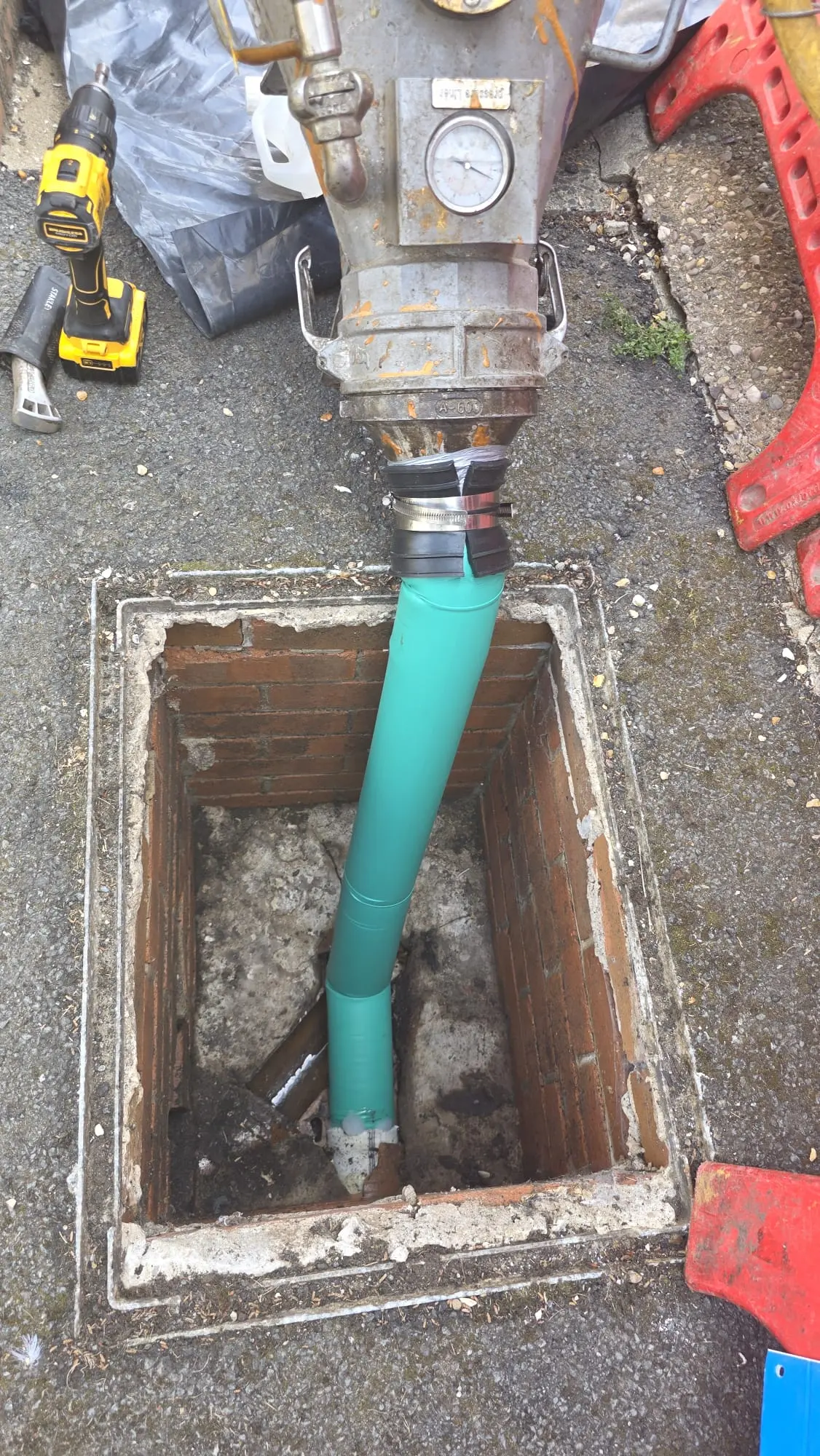 Drain relining equipment being used to insert a green liner into an open manhole for trenchless pipe repair in Sunderland.