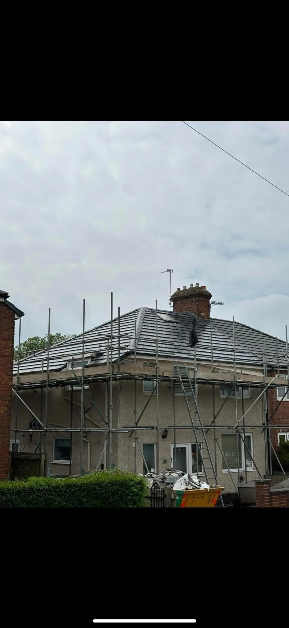 A newly installed grey tiled roof on a residential house with scaffolding in Otley
