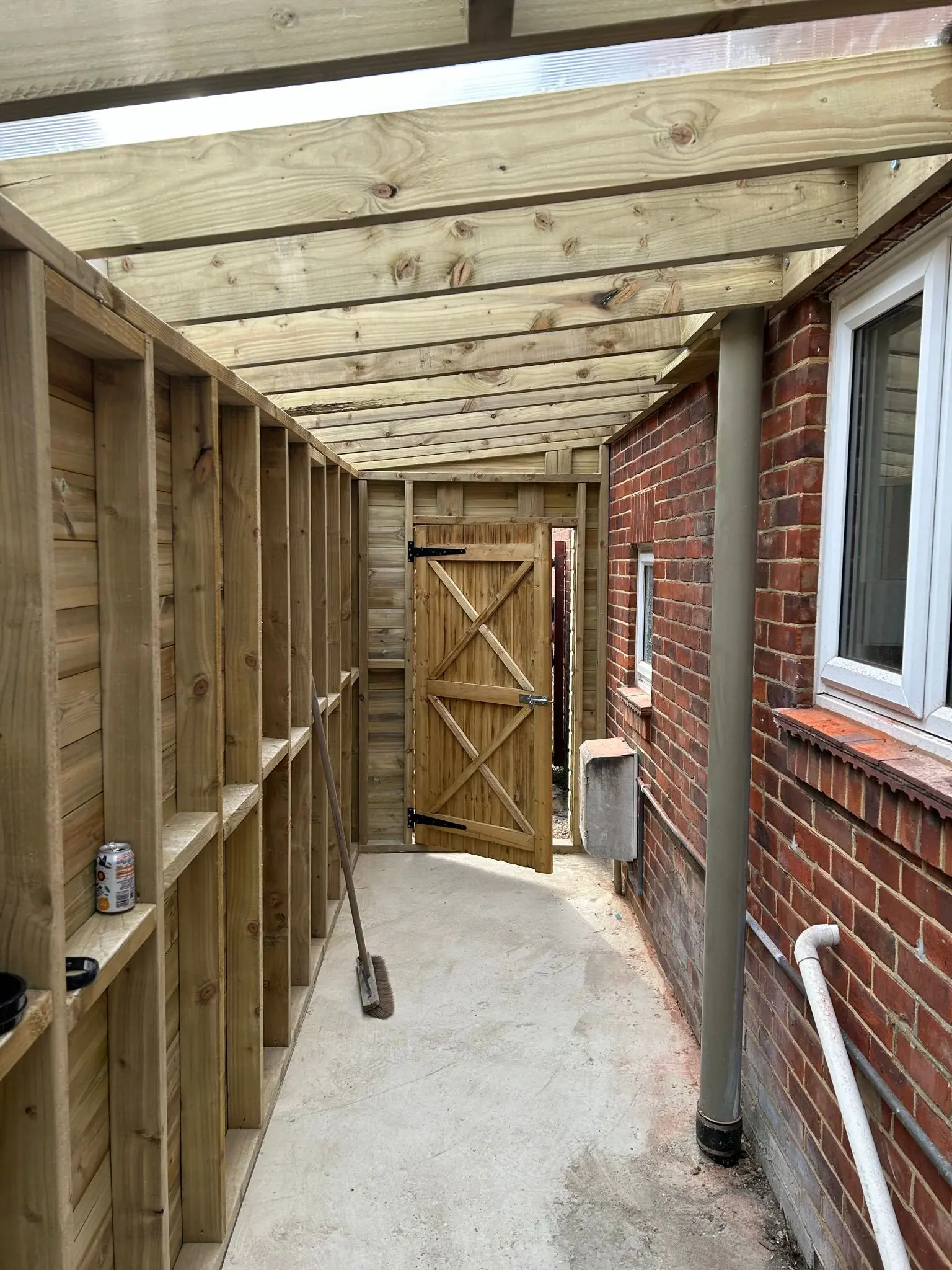 Timber framed lean-to extension attached to a brick house under construction