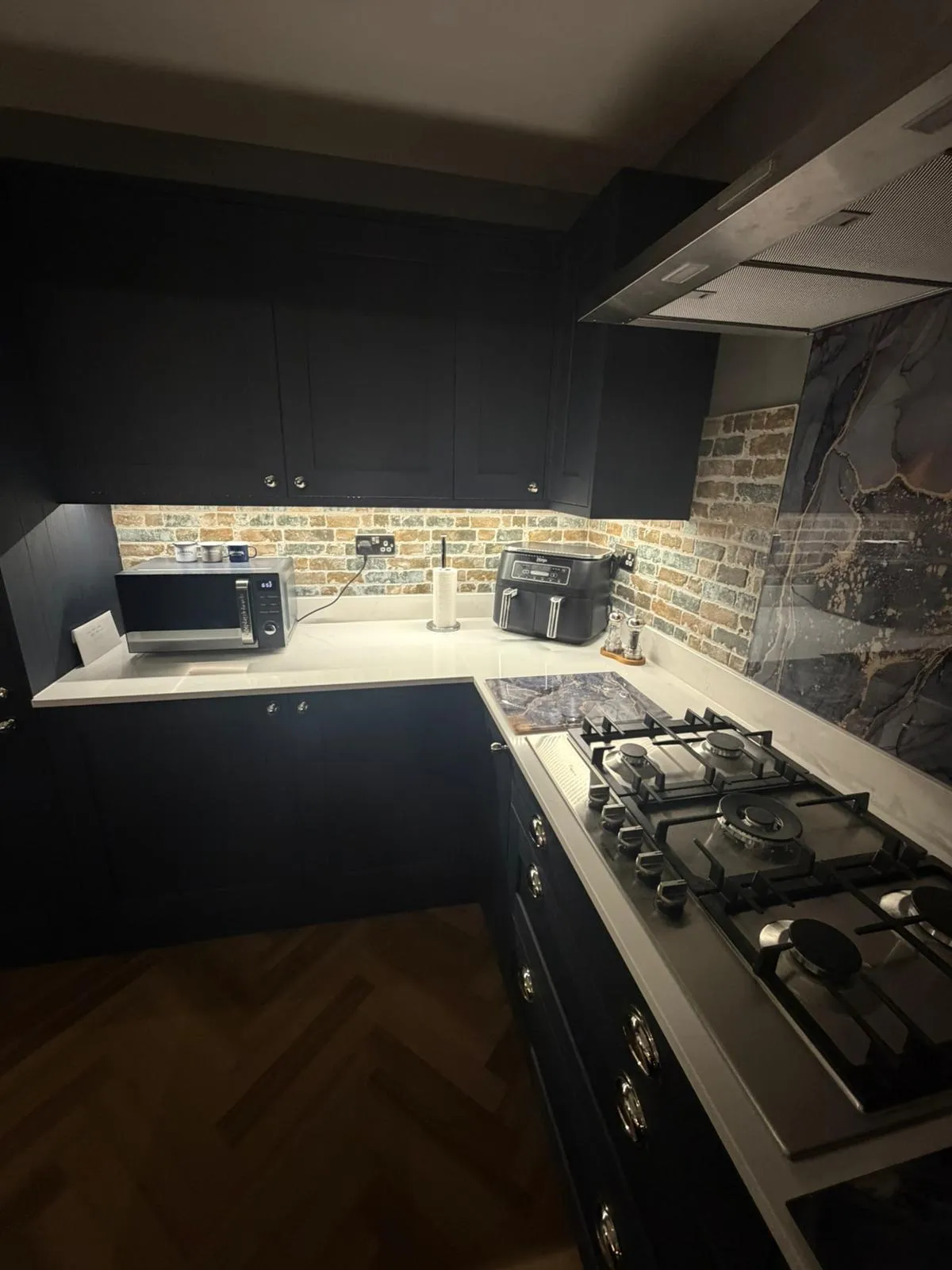 Modern kitchen installation in Felixstowe featuring navy blue cabinetry and under-cabinet lighting by FLEX PROPERTY SERVICES